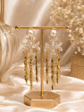 Pearl and crystal flower gold tassel drop earrings on display stand