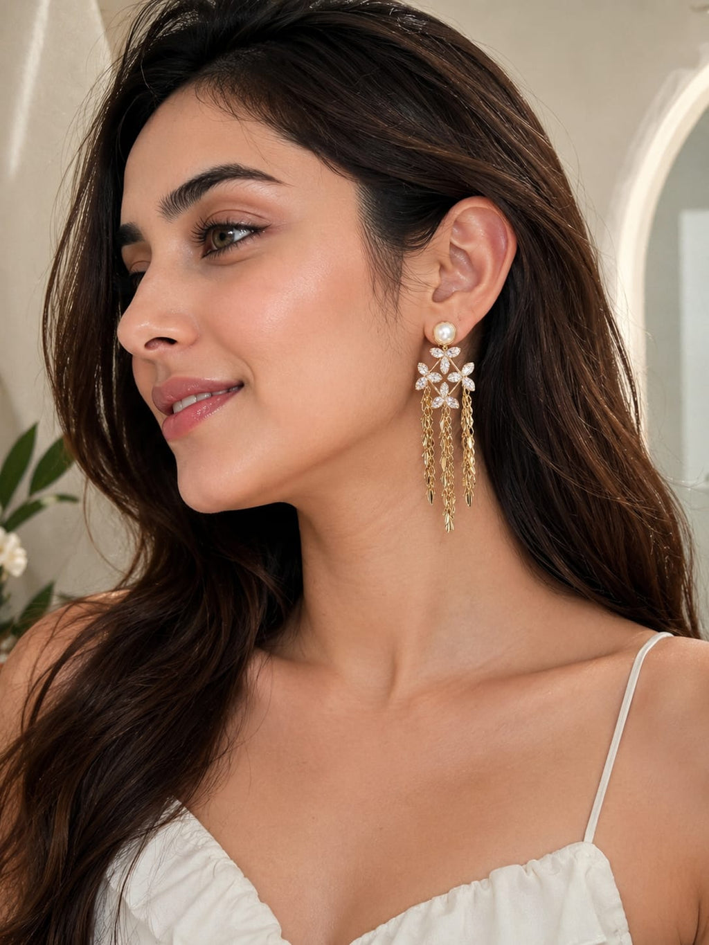 Model wearing pearl and crystal flower gold tassel drop earrings